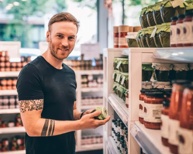 Privatkoch Sascha Zellinger vor einem Regal im Feinkostladen