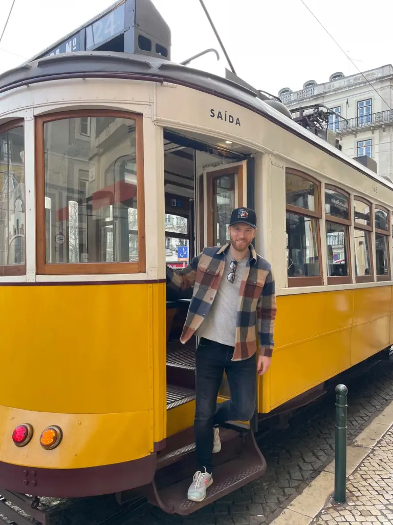 Privatkoch Sascha Zellinger steigt aus einer gelben Straßenbahn in Lissabon – kulinarische Reisen durch Europa